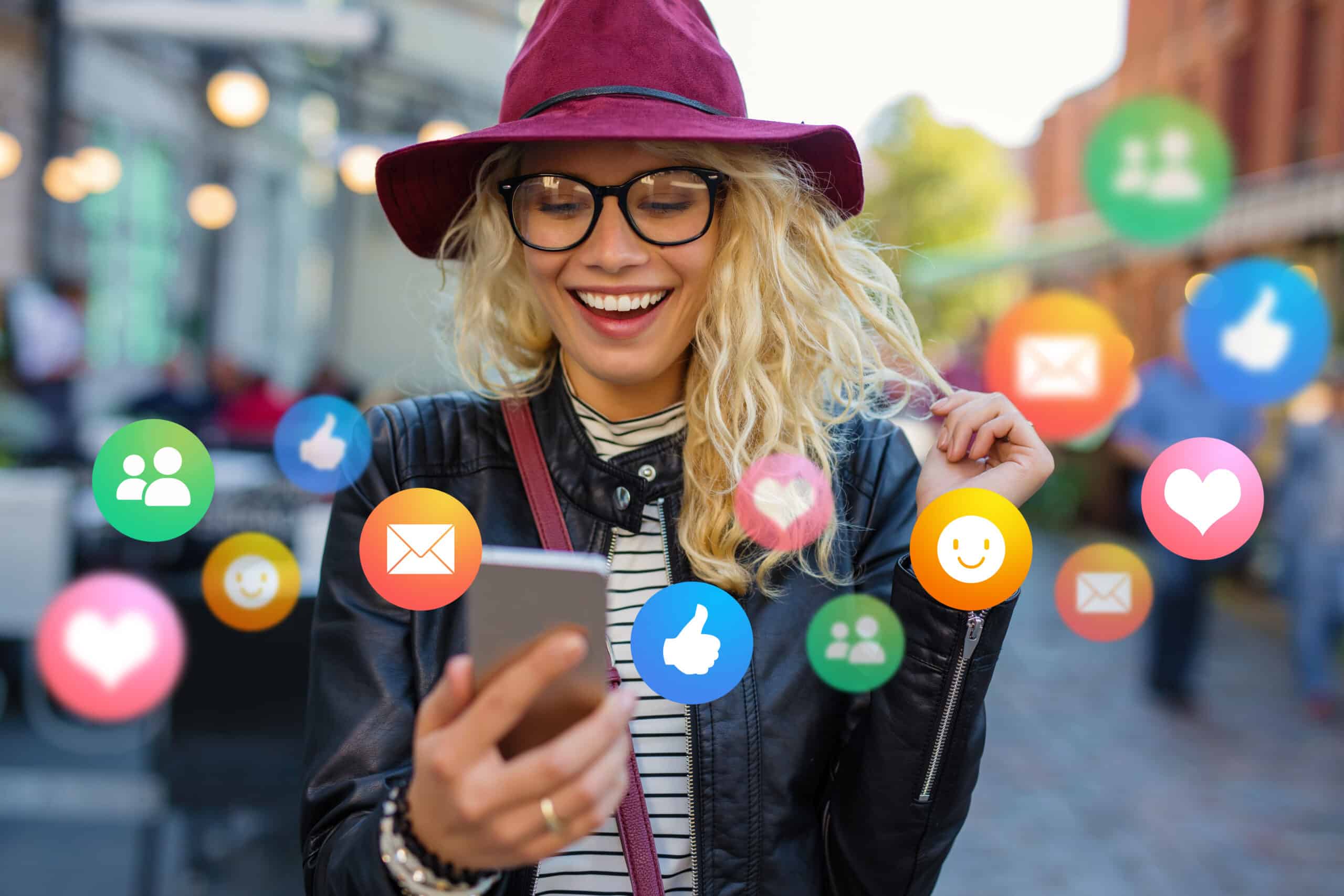 A woman holds her mobile phone with a feed of social channels such as Facebook, X and Instagram.