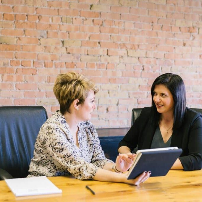 Two female employees discuss background checks in Gothenburg